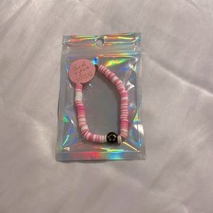 Pink and white clay bead bracelet with charm